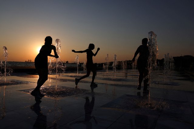 Youths play in a fountain during a hot day in Thessaloniki, Greece on July 21, 2025. (Photo by Alexandros Avramidis/Reuters)