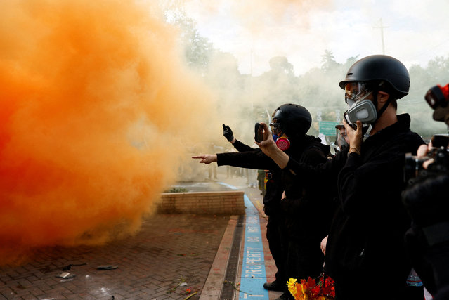 Demonstrators react to a smoke grenade released by law enforcement officers in front of U.S. Immigration and Customs Enforcement (ICE) headquarters in south Portland, Oregon, U.S., October 4, 2025. (Photo by John Rudoff/Reuters)