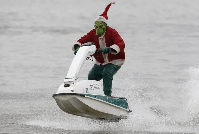 A jet ski rider, dressed as the Grinch, takes part in the 29th annual Christmas Eve water performance on the Potomac River in Alexandria, Virginia, December 24, 2014. (Photo by Larry Downing/Reuters)