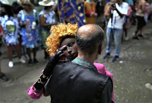 A patient from the Nise de Silveira mental health institute dances with a doll during the institute's carnival parade, called in Portuguese: “Loucura Suburbana”, or Suburban Madness, in the streets of Rio de Janeiro, Brazil, Thursday, February 16, 2023. Patients, their relatives and workers from the institute held their parade before the start of Carnival which begins on Feb. 17. (Photo by Silvia Izquierdo/AP Photo)