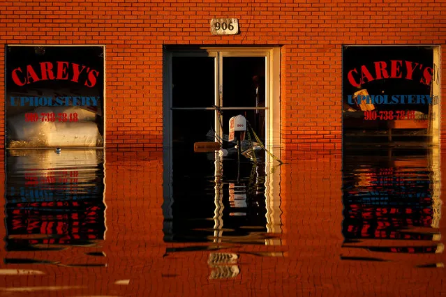 A store front is reflected in flood waters as a result of Hurricane Matthew in Lumberton, North Carolina, U.S. October 12, 2016. (Photo by Carlo Allegri/Reuters)
