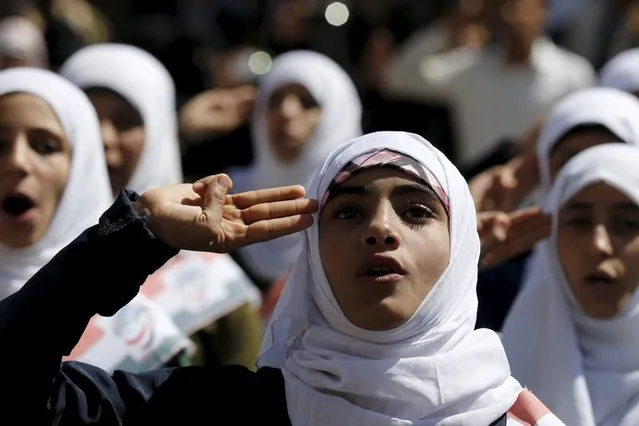 Students salute for the national anthem as they take part in a protest against the Saudi-led air strikes outside the Russian embassy in Yemen's capital Sanaa November 26, 2015. (Photo by Khaled Abdullah/Reuters)