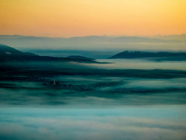 An aerial view taken with a drone of morning fog lingering over a landscape near Cered, Hungary, 12 September 2025. (Photo by Péter Komka/EPA)