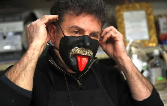 Venetian artisan carnival mask maker Gualtiero Dall'Osto wears one of his creations in his workshop in Venice, Italy, Saturday, January 30, 2021. (Photo by Antonio Calanni/AP Photo)