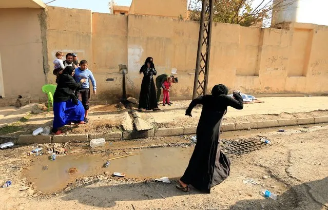 Displaced people who fled Hammam al-Alil, south of Mosul, run from clashes as they head to safer territory, Iraq November 6, 2016. (Photo by Thaier Al-Sudaini/Reuters)