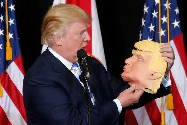 Republican presidential nominee Donald Trump looks at a mask of himself as he speaks during a campaign rally in Sarasota, Florida, U.S. November 7, 2016. (Photo by Carlo Allegri/Reuters)