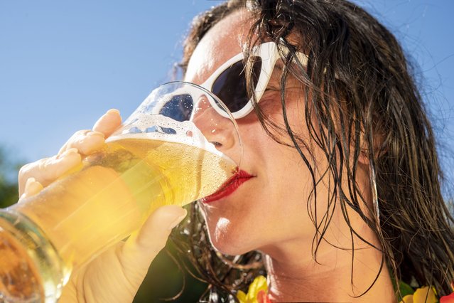 Young woman drinks beer from a tall glass on a hot summer day. (Photo by ilmoro100/Getty Images)