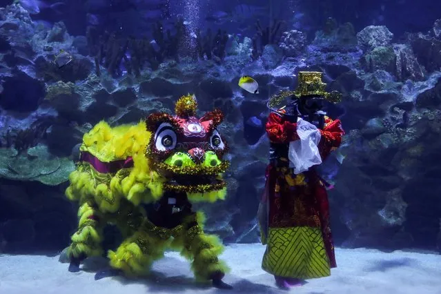 Divers perform an underwater lion dance at KLCC Aquaria during Lunar New Year celebrations in Kuala Lumpur, Malaysia on February 12, 2021. (Photo by Lim Huey Teng/Reuters)