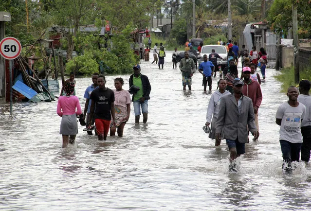 People make their way through floodwaters in Beira Mozambique, Saturday, January 23, 2021. The Mozambican port city of Beira breathed a sigh of relief as Cyclone Eloise caused less damage than feared as it passed through, but the danger of flooding remained in a region still recovering from a devastating cyclone two years ago. (Photo by AP Photo/Stringer)