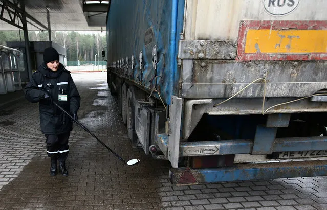 A Belarussian border guard checks a truck with a mirror at a checkpoint Kotlovka at the border between Belarus and Lithuania, near the village of Kotlovka, Belarus, November 22, 2016. (Photo by Vasily Fedosenko/Reuters)