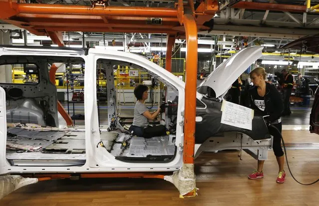 Fiat Chrysler assembly workers work on a partially assembled minivan at the Windsor Assembly Plant in Windsor, Ontario, February 9, 2015. The plant prepares to shut down for 14 weeks starting February 16 in preparation for Fiat Chrysler's next generation minivan. (Photo by Rebecca Cook/Reuters)