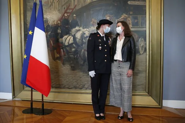 French math teacher-volunteer fighter, Marion Dehecq, left, poses with Paris-based Associated Press journalist Lori Hinnant, after she receives a bronze medal for courage and dedication as she used CPR to save the life of a jogger, during a ceremony with France's minister for citizenship issues, Marlene Schiappa at the Paris fire service headquarters in Paris, France, Monday, May 10, 2021. The jogger's wife, Paris-based Associated Press journalist Lori Hinnant, helped identify the anonymous rescuer by putting up thank-you signs in Monceau Park, where her husband Peter Sigal went into cardiac arrest on April 28. (Photo by Francois Mori/AP Photo/Pool)