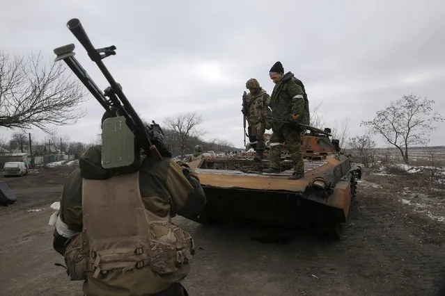 Fighters with the separatist self-proclaimed Donetsk People's Republic army stand on top of a destroyed Ukrainian armoured personnel carrier at a check point on the road from the town of Vuhlehirsk to Debaltseve, February 20, 2015.
REUTERS/Baz Ratner (UKRAINE - Tags: POLITICS CIVIL UNREST CONFLICT MILITARY)
