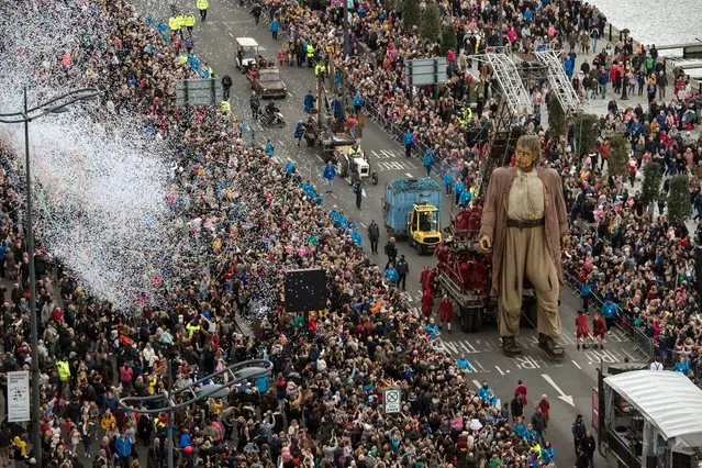A huge puppet named Giant walks past the dockside in central Liverpool, north west England on October 7, 2018, during a production by French street theatre company Royal de Luxe entitled: Liverpool's Dream. Royal de Luxe was founded in Nantes in 1979 by Jean-Luc Courcoult and has played in front of more than 24 million spectators with around 1,500 shows in over 170 cities on 5 continents. The “Giants” puppets were created in 1993 and have travelled all over the world taking over cities including Berlin, Barcelona, Santiago, Antwerp, Guadalajara, Perth and Montreal. (Photo by Oli Scarff/AFP Photo)