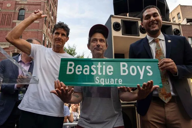 Adam “Adrock” Horowitz (C) and Michael “Mike D” Diamond (L) of the hip hop music band Beastie Boys, with New York City Council Member Christopher Marte (R), unveil “Beastie Boys Square”, in the Manhattan borough of New York City on September 9, 2023. The corner at the intersection of Ludlow and Rivington streets was the gatefold cover for the band's second album “Paul’s Boutique”. (Photo by Adam Gray/AFP Photo)