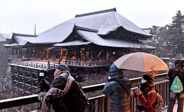 Sightseers enjoy a first view of Kiyomizudera temple covered with snow in this season in Higashi Ward, Kyoto on January 20, 2016. The Japan Meteorological Agency has warned people to remain alert for blizzards, heavy snow, strong winds and high waves especially in Kinki region until Jan. 21. (Photo by The Yomiuri Shimbun via AP Images)