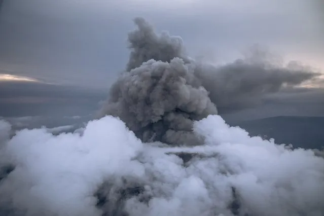 This aerial photo taken on May 30, 2021 shows the column of ash expelled from the crater of Nyiragongo volcano, north of Goma, the provincial capital of North Kivu. The Nyiragongo, Africa's most active volcano, located in the Virunga National Park, erupted on May 22, 2021, killing 32 people and sweeping away the electricity facilities. The possibility of a second eruption in the coming days is not ruled out by scientists on the ground. (Photo by Alexis Huguet/AFP Photo)