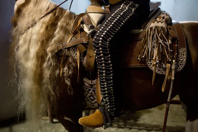In this February 26, 2015 photo, a charro sits atop his horse as he waits to enter the arena, during a charreada in Mexico City. For National Association team member Fernando Armando Juarez Manzur, who began riding at age two and is now 40, being a charro is both a way of life and an identity. “When one dresses up as a charro in any part of the world, one knows you are a Mexican”. (Photo by Rebecca Blackwell/AP Photo)
