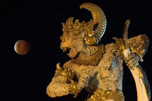 The full moon, known as “Super Blood Moon”, rises over the Titi Banda park in Denpasar, Bali, Indonesia on May 26, 2021. (Photo by Nyoman Budhiana/Antara Foto via Reuters)