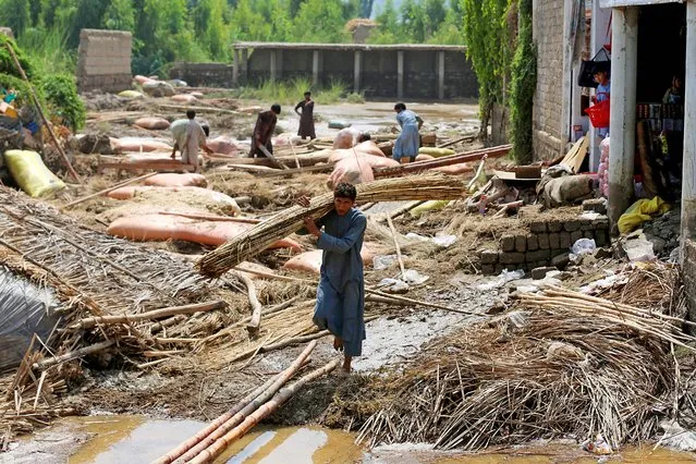Afghan villagers clean debris after flash floods in Mohmand Dara district of Nangarhar province on September 18, 2023. (Photo by Shafiullah Kakar/AFP Photo)