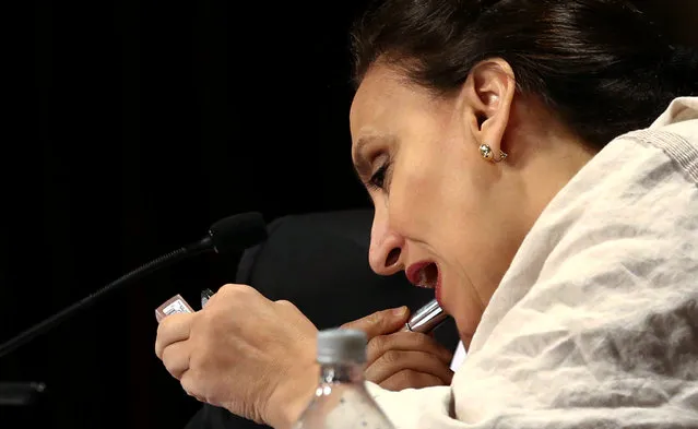 Gabriela Michetti, Argentina’s Vice-President and President of the Senate, applies lipstick during a session to vote on an income tax reform bill at Congress in Buenos Aires, Argentina, December 21, 2016. (Photo by Marcos Brindicci/Reuters)