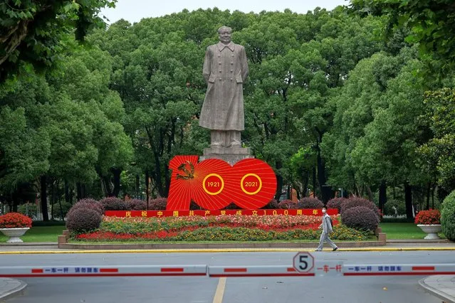 A student passes the statue of Chinese leader Mao Zedong and a signboard of marking the 100th founding anniversary of the Communist Party of China, at Fudan University in Shanghai, ahead of the 100th founding anniversary of the party, in Shanghai, China on June 25, 2021. (Photo by Aly Song/Reuters)
