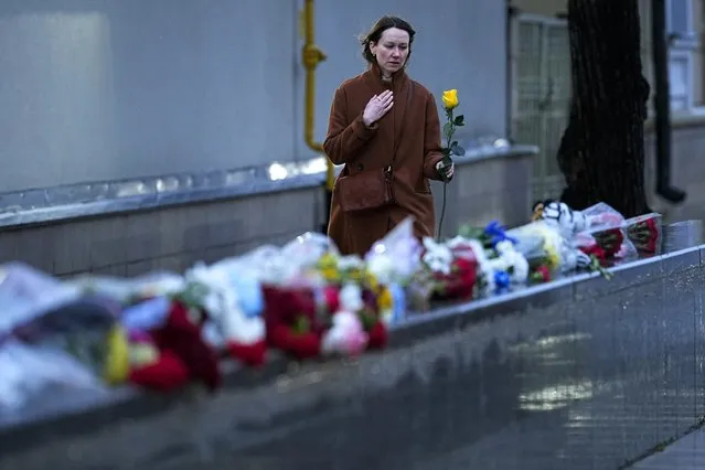 A woman lays flowers in memory of victims after the surprise attack from Gaza, in front of the Israeli Embassy in Moscow, Russia, Sunday, October 8, 2023. Israeli media say at least 600 people have been killed, including more than 40 soldiers. (Photo by Alexander Zemlianichenko/AP Photo)