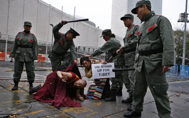 Actors dressed as Chinese soldiers pretend to beat a Tibetan monk and a Tibetan woman in traditional dress as they hold a protest outside the United Nations headquarters in New York, November 12, 2013. The protest, organized by Students for a Free Tibet, came on the day of China's bid to be re-elected to the U.N. Human Rights Council on November 12. (Photo by Mike Segar/Reuters)