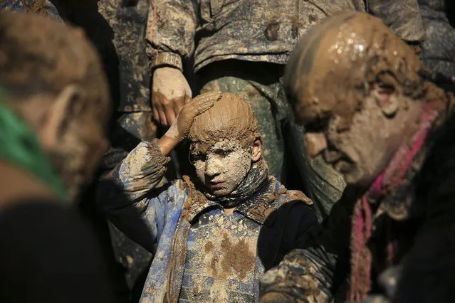 Iranian Shiites cover themselves with mud during Ashoura, marking the death anniversary of Imam Hussein, the grandson of Islam's Prophet Muhammad, at the city of Bijar, west of the capital Tehran, Iran, Thursday, November 14, 2013. (Photo by Ebrahim Noroozi/AP Photo)