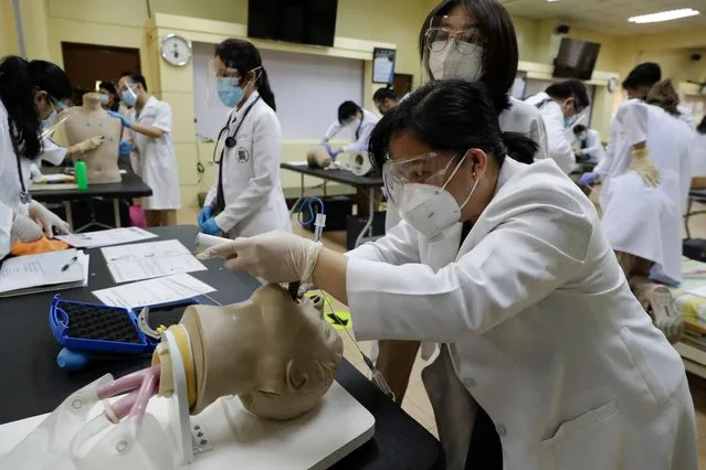 Dr. Flordeluna Mesina demonstrates an endotracheal intubation on a dummy on the second day of limited face-to-face classes at the University of Santo Tomas in Manila, Philippines on Thursday, June 10, 2021. (Photo by Aaron Favila/AP Photo)