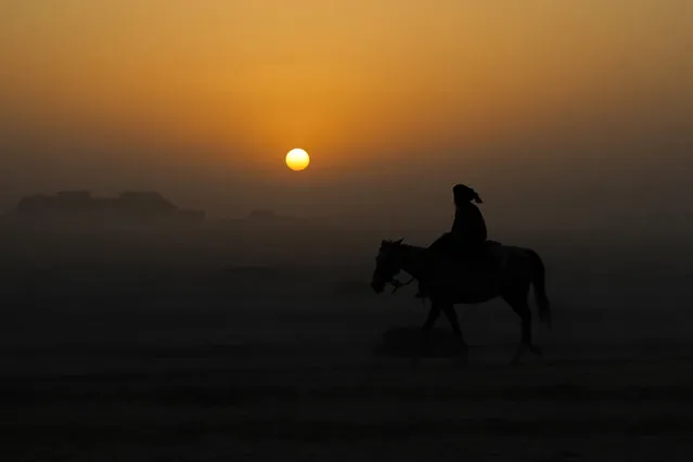 An Afghan man rides a horse as the sun sets in Dawlatabad district of Balkh province on October 10, 2023. (Photo by Ahmad Sahel Arman/AFP Photo)