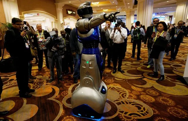 A man in a mechanized robotic costume points the way for showgoers to the CES Unveiled event at CES in Las Vegas, January 3, 2017. (Photo by Rick Wilking/Reuters)