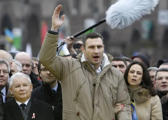 Vitaly Klitschko (C), heavyweight boxing champion and UDAR (Punch) party leader, his wife Natalia (R, first row) and Jaroslaw Kaczynski (L, first row), leader of Poland's main opposition Law and Justice Party (PiS), attend a rally held by supporters of EU integration in Kiev, December 1, 2013. Ukrainian opposition leader Vitaly Klitschko, addressing hundreds of thousands of protesters in central Kiev, called on President Viktor Yanukovich and his government to resign, saying they had “stolen” Ukraine's dream of European integration. (Photo by Vasily Fedosenko/Reuters)