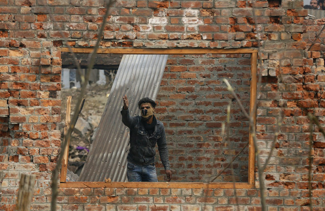 In this Sunday, December 9, 2018, file photo, a Kashmiri man shouts at an Indian policeman as he stands inside a damaged house at the site of a gun-battle in Mujagund area some 25 Kilometers (16 miles) from Srinagar, Indian controlled Kashmir. Indian troops killed three suspected rebels in the outskirts of disputed Kashmir's main city ending nearly 18-hour-long gunbattle, officials said Sunday. (Photo by Mukhtar Khan/AP Photo)