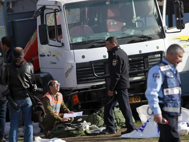 Israeli police investigates the scene of an attack in Jerusalem Sunday, January 8, 2017. A Palestinian rammed his truck into a group of Israeli soldiers in Jerusalem on Sunday, killing four people and wounding 15 others, Israeli police and rescue services said, in one of the deadliest attacks of a more than yearlong campaign of violence. (Photo by Mahmoud Illean/AP Photo)