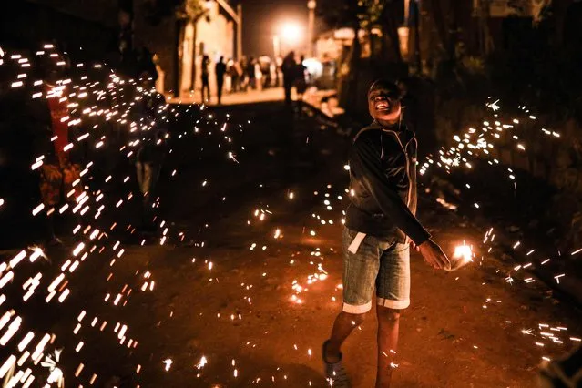 A boy burns steel wool to make sparks during New Year celebrations in the Kibera slum in Nairobi on January 1, 2019. (Photo by Brian Otieno/AFP Photo)