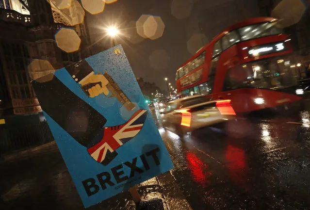 Vehicles drive past an anti-Brexit placard that is placed near the Parliament in London, Tuesday, January 29, 2019. Britain's Parliament is set to vote on competing Brexit plans, with Prime Minister Theresa May desperately seeking a mandate from lawmakers to help secure concessions from the European Union. (Photo by Alastair Grant/AP Photo)
