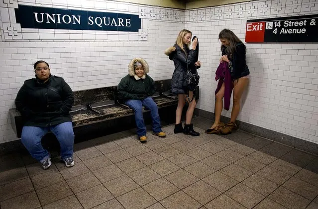 Leah Estreicher and Marianne Cornejo start to get dressed at the Union Square subway station after participating in the annual No Pants Subway Ride in New York. (Photo by Craig Ruttle/Associated Press)