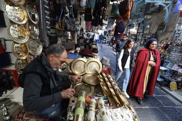 A Tunisian craftsman carves designs into a copper disk in the souk (open-air market) of the old city in Tunis, Tunisian, 17 January 2024. The centuries-old practice of engraving on metals such as gold, silver and copper, was inscribed on UNESCO's Intangible Cultural Heritage List in December 2023. Ten countries including Egypt, Iraq, Algeria, Mauritania, Morocco, Palestine, Saudi Arabia, Sudan, Tunisia and Yemen, have collaborated in the nomination process. (Photo by Mohamed Messara/EPA)
