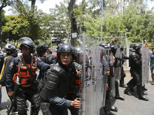 A cordon of Venezuelan National Police officers retreat when confronted by demonstrators who were temporarily blocked by police from getting to a rally against the government of President Nicolas Maduro in Caracas, Venezuela, Saturday, March 9, 2019. (Photo by Fernando Llano/AP Photo)