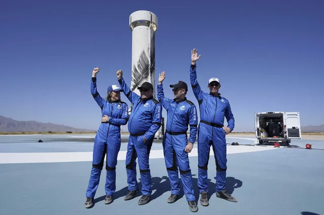 Blue Origin's New Shepard rocket latest space passengers from left, Audrey Powers, William Shatner, Chris Boshuizen, and Glen de Vries raises their hands as they talks about snake bites during a media availability at the spaceport near Van Horn, Texas, Wednesday, October 13, 2021. (Photo by L.M. Otero/AP Photo)