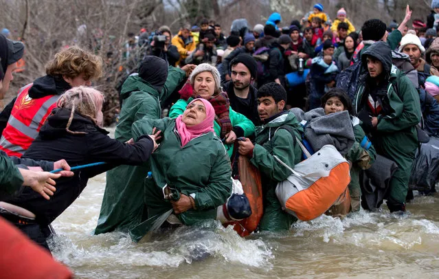 Migrants cross a river after leaving the Idomeni refugee camp on March 14, 2016 in Idomeni, Greece. The decision by Macedonia to close its border to migrants on Wednesday has left thousands of people stranded at the Greek transit camp. The closure, following the lead taken by neighbouring countries, has effectively sealed the so-called western Balkan route, the main migration route that has been used by hundreds of thousands of migrants to reach countries in western Europe such as Germany.  (Photo by Matt Cardy/Getty Images)