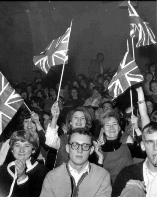 American fans of the British group The Beatles wave the Union Flag during their performance at the Coliseum, Washington, February 11, 1964. (Photo by AP Photo)