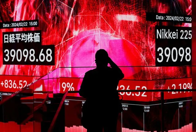 A visitor using his smartphone takes photos of an electronic screen displaying Japan's Nikkei share average, which surged past an all-time record high scaled in December 1989, inside a building in Tokyo, Japan on February 22, 2024. (Photo by Issei Kato/Reuters)
