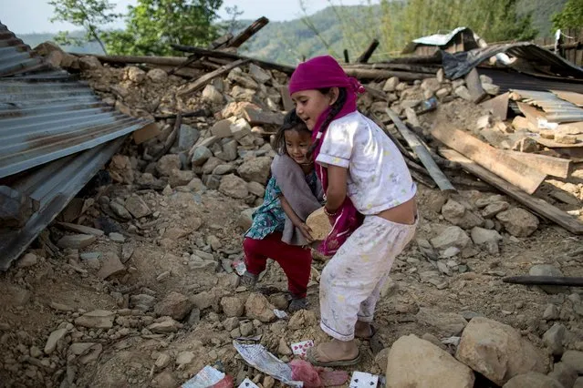 Reshmila, 8, (R) and Shamjana, 5, throw debris as they play at the site of their collapsed house after an earthquake in a village in Sindhupalchowk, Nepal, May 2, 2015. (Photo by Danish Siddiqui/Reuters)