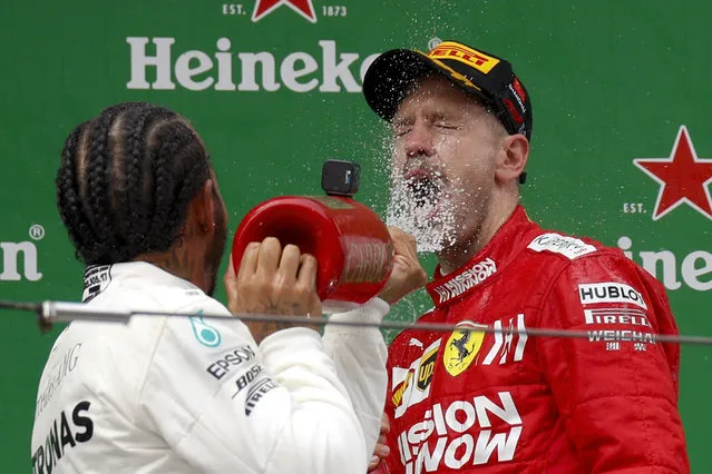 In this Sunday, April 14, 2019, file photo, Mercedes driver Lewis Hamilton of Britain sprays champagne to Ferrari driver Sebastian Vettel of Germany after winning the Chinese Formula One Grand Prix at the Shanghai International Circuit in Shanghai. Vettel finished third. (Photo by Andy Wong/AP Photo/File)