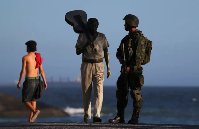 A Brazilian navy soldier patrols the area near the statue of Brazilian musician Tom Jobim at the Arpoador Beach before carnival festivities in Rio de Janeiro, Brazil February 14, 2017. (Photo by Sergio Moraes/Reuters)