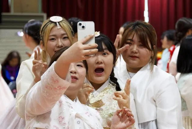 Graduates wearing traditional Korean clothes take a selfie during their graduation ceremony at the Dongmyung Girls High School in Seoul, South Korea,  on February 6, 2024. (Photo by Jeon Heon-Kyun/EPA/EFE)