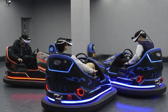 In this April 2, 2019, photo, visitors drive virtual reality bumper cars in a VR theme park in Nanchang, China. One of the largest virtual reality theme parks in the world has opened its doors in southwestern China, sporting 42 rides and exhibits from VR roller coasters to VR shoot-em-ups. It's part of an effort by Beijing to get ordinary people excited about the technology – part of a long-term bet that VR will come into widespread use. (Photo by Dake Kang/AP Photo)