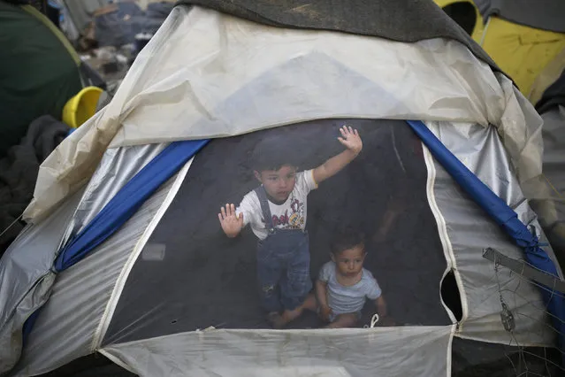 Children look out from a tent at a makeshift camp for migrants and refugees at the Greek-Macedonian border near the village of Idomeni, Greece, April 1, 2016. (Photo by Marko Djurica/Reuters)